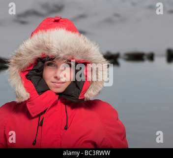 Giovane ragazza in parka guarnizioni in background, Jokulsarlon, Breidamerkurjokull Glacier, Islanda Foto Stock