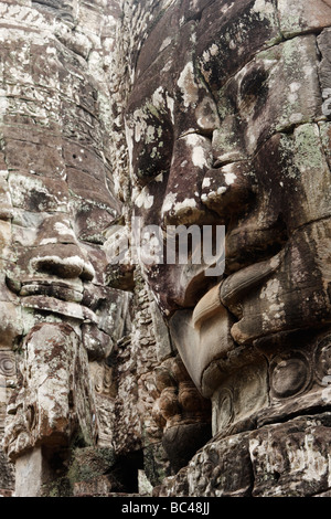 "Chiudere l' di grande faccia sorridente scolpite nella pietra, tempio Bayon rovine, [Angkor Thom], Cambogia Foto Stock