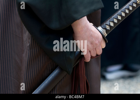 Un'immagine ravvicinata di un uomo in possesso di un vero samurai giapponese spada katana o durante un arti marziali dimostrazione a Kyoto in Giappone Foto Stock