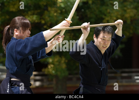 Due persone sparring con dei bastoni di legno in una formazione swordsmanship esercizio chiamato kenjutsu durante un arti marziali dimostrazione Foto Stock