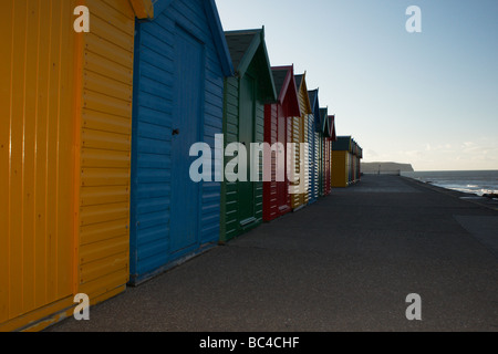 Spiaggia di capanne lungo il fronte spiaggia a Whitby Yorkshire Inghilterra nel sole di sera Foto Stock
