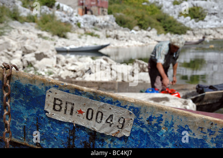 Un pescatore montenegrino prepara la sua barca per imbarco sul Lago di Scutari. Foto Stock