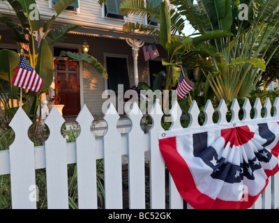 Picket Fence davanti a casa con noi le bandiere e pavese Foto Stock