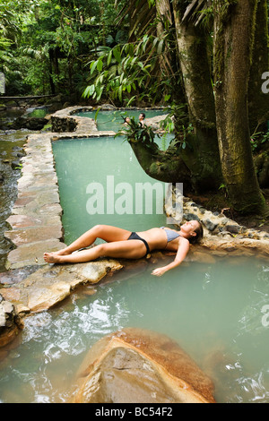 Una giovane donna in un naturale sorgenti termali e spa o dei bagni caldi in La Fortuna, Costa Rica vicino a Arenal Foto Stock