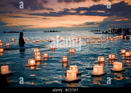 Lanterne galleggianti drift pigramente in acqua come il sole tramonta su Honolulu, Hawaii Foto Stock