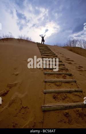 Donna festeggia la sua scalata su una duna di sabbia, spirito Sands, boschi di abete rosso Parco Provinciale, Manitoba, Canada. Foto Stock