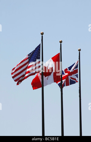 Bandiere USA British Canadian su un palo contro il cielo blu angolo basso ritaglio sfondo isolato in Ohio Stati Uniti nessuno verticale ad alta risoluzione Foto Stock