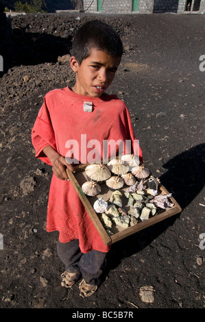 Il ragazzo nativo di vendere qualcosa davanti a casa sua vulcano in background Fogo Cabo Verde in Africa Foto Stock