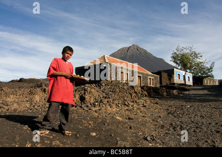 Il ragazzo nativo di vendere qualcosa davanti a casa sua vulcano in background Fogo Cabo Verde in Africa Foto Stock