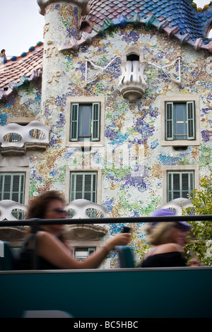 Autobus turistico che viaggiano nella parte anteriore della Casa Batlló quartiere Eixample di Barcellona Spagna Foto Stock