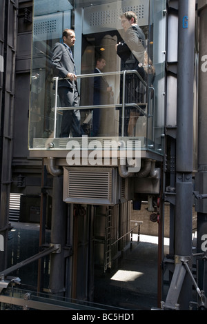 Gli impiegati in un ascensore presso la Lloyds edificio nella città di Londra Foto Stock