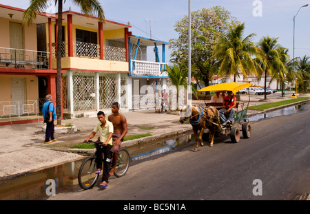 Scene di strada di trasporto e la vita reale lungo il Malacon a Cienfuegos Cuba con carrozze trainate da cavalli Foto Stock