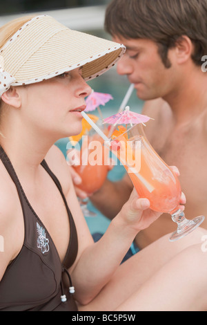 L uomo e la donna a bere Planter's Punch in piscina - Foto Stock