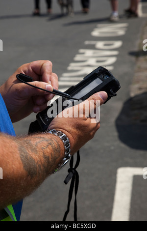 Registrazione di nessuna violazione di parcheggio  Meter Attendant che emette il biglietto utilizzando il dispositivo portatile, Helmsley, North Yorkshire Regno Unito Foto Stock