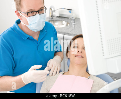 Maschio di dentista e paziente guardando il monitor Foto Stock