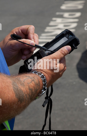 Registrazione di nessuna violazione di parcheggio  Meter Attendant che emette il biglietto utilizzando il dispositivo portatile, Helmsley, North Yorkshire Regno Unito Foto Stock