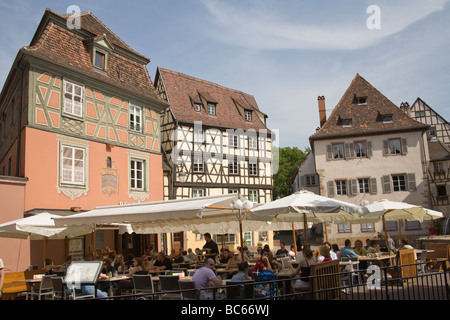 Colmar Alsace Francia UE ai visitatori per cenare fuori nel sole di primavera in un ristorante a Place de L Ancienne Douane Foto Stock