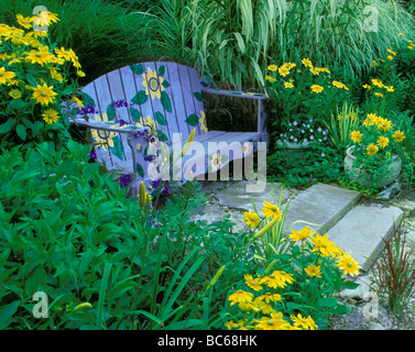 Un po' di divertimento: dipinto a mano blu panchina da giardino con girasoli seduto tra spazio privato, Midwest USA Foto Stock