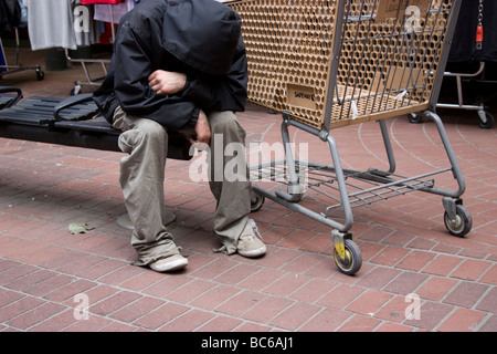 Ricchi poveri dividono la disuguaglianza, Vancouver Canada senzatetto con carrello della spesa Foto Stock