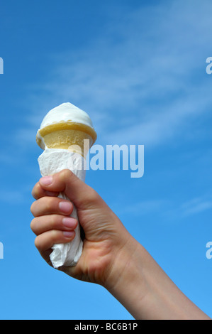 Un ragazzo giovane azienda il suo cono gelato. Foto Stock