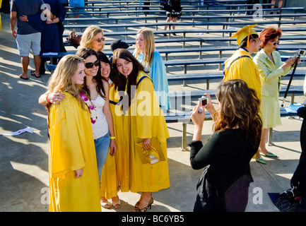 Felice la laurea liceo anziani posano per una famiglia foto di gruppo dopo outdoor inizio esercizi in Huntington Beach CA Foto Stock