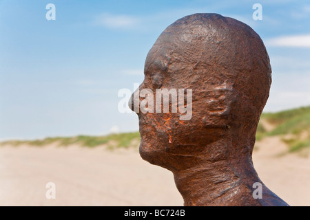Uno di Antony Gormley "un altro posto' iron man statue. Crosby Beach, Liverpool, Merseyside, Regno Unito. Foto Stock