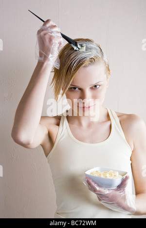 Donna di colorante di applicazione sui capelli Foto Stock