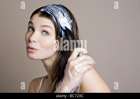 Donna di colorante di applicazione sui capelli Foto Stock