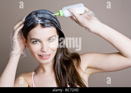 Donna di colorante di applicazione sui capelli Foto Stock