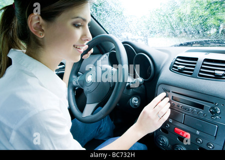 Donna che utilizza auto stereo Foto Stock