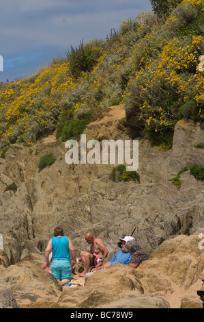 La gente seduta tra le rocce a Woolacombe Bay North Devon England Foto Stock