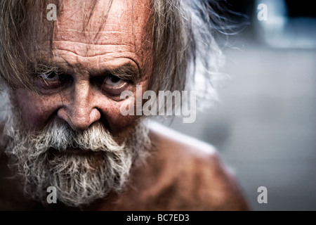 Robusto e pazzo cercando, stropicciata uomo anziano con i capelli grigi e la barba. Foto Stock