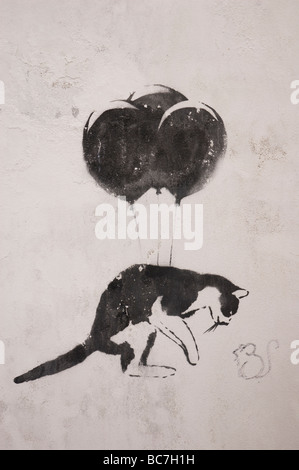 Graffiti del gatto con baloons fissando poco del mouse sulla parete edilizia a Viana do Castello, Porugal Foto Stock