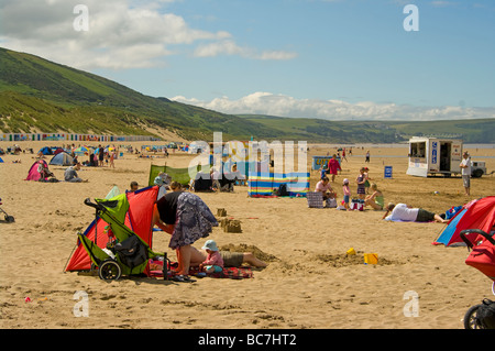 I turisti in riva al mare sulla spiaggia a Woolacombe Bay North Devon England Regno Unito Foto Stock