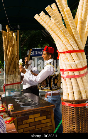 La Turchia , Istanbul , Sultanahmet , tradizionale fornitore di gelati con fez serve teatrale con un lungo cucchiaio di metallo & campane delle mucche Foto Stock