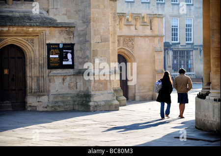 Un giovane a piedi tra Abbazia e le terme romane di Bath Regno Unito Foto Stock