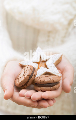 Mani che tengono i biscotti di Natale - Foto Stock