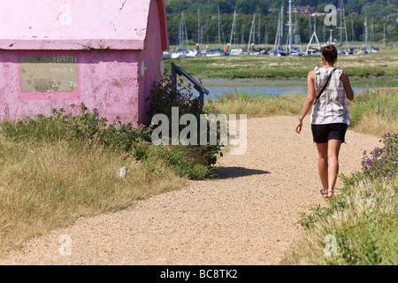 Un attraente giovane donna cammina sul Solent modo a Warsash passando il traghetto Shelter Hampshire REGNO UNITO Foto Stock