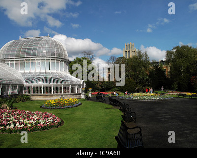 Palm house progettata da Charles Lanyon nel giardino botanico di Belfast, con la nuova biblioteca presso la Queen's University Foto Stock