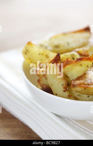 Pane appena sfornato ciotola di rosmarino e aglio aromatizzato Spicchi di patate con n. di persone Foto Stock