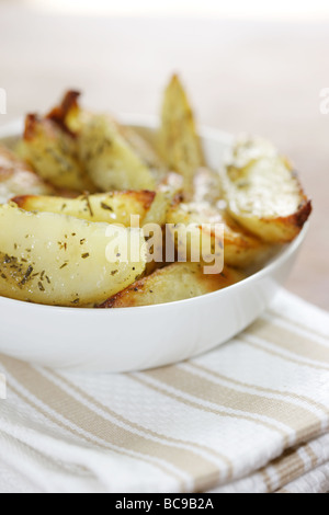 Pane appena sfornato ciotola di rosmarino e aglio aromatizzato Spicchi di patate con n. di persone Foto Stock