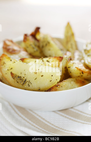 Pane appena sfornato ciotola di rosmarino e aglio aromatizzato Spicchi di patate con n. di persone Foto Stock