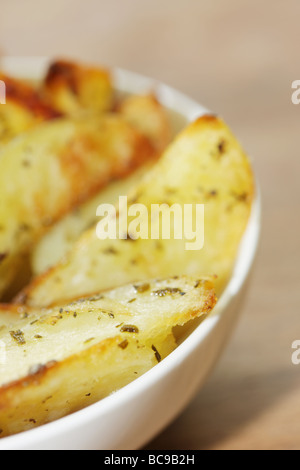 Pane appena sfornato ciotola di rosmarino e aglio aromatizzato Spicchi di patate con n. di persone Foto Stock