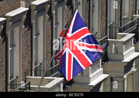 La Union Jack flag vola alto oltre un tipicamente London street scene dotate di una fila di Georgiani terrazzati proprietà. Foto Stock