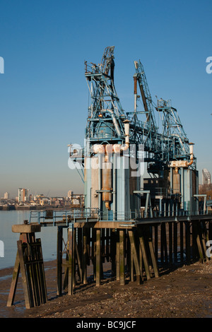 Vecchio molo industriale con tubi arrugginito contro un cielo blu chiaro Foto Stock