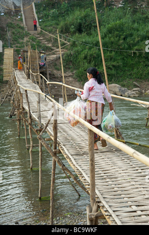 Un Lao donne attraversando il ponte di bambù sul fiume Nam Khan in Luang Prabang Laos Foto Stock