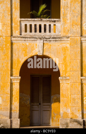 Weathered giallo francese coloniale a archway e balcone in Phnom Penh Cambogia Foto Stock