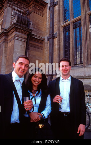 Università di Oxford gli studenti in subfusc (abito tradizionale) bere champagne al di fuori del college universitario dopo finals England Regno Unito Foto Stock