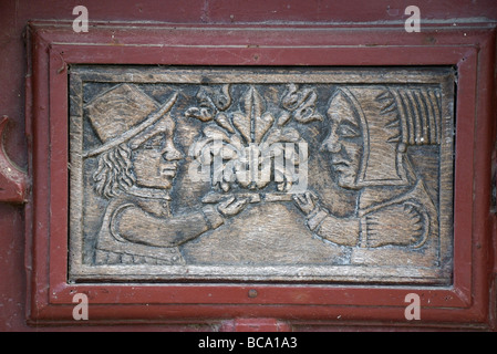 Maschio storico e figure femminili nel pannello porta in legno, Roscoff, Bretagna Francia Foto Stock