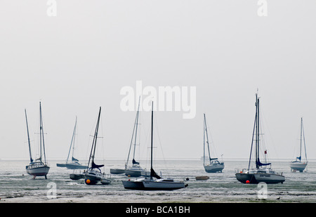 Barche spiaggiate sul fango a bassa marea vicino a Leigh sul mare in Essex. Foto Stock